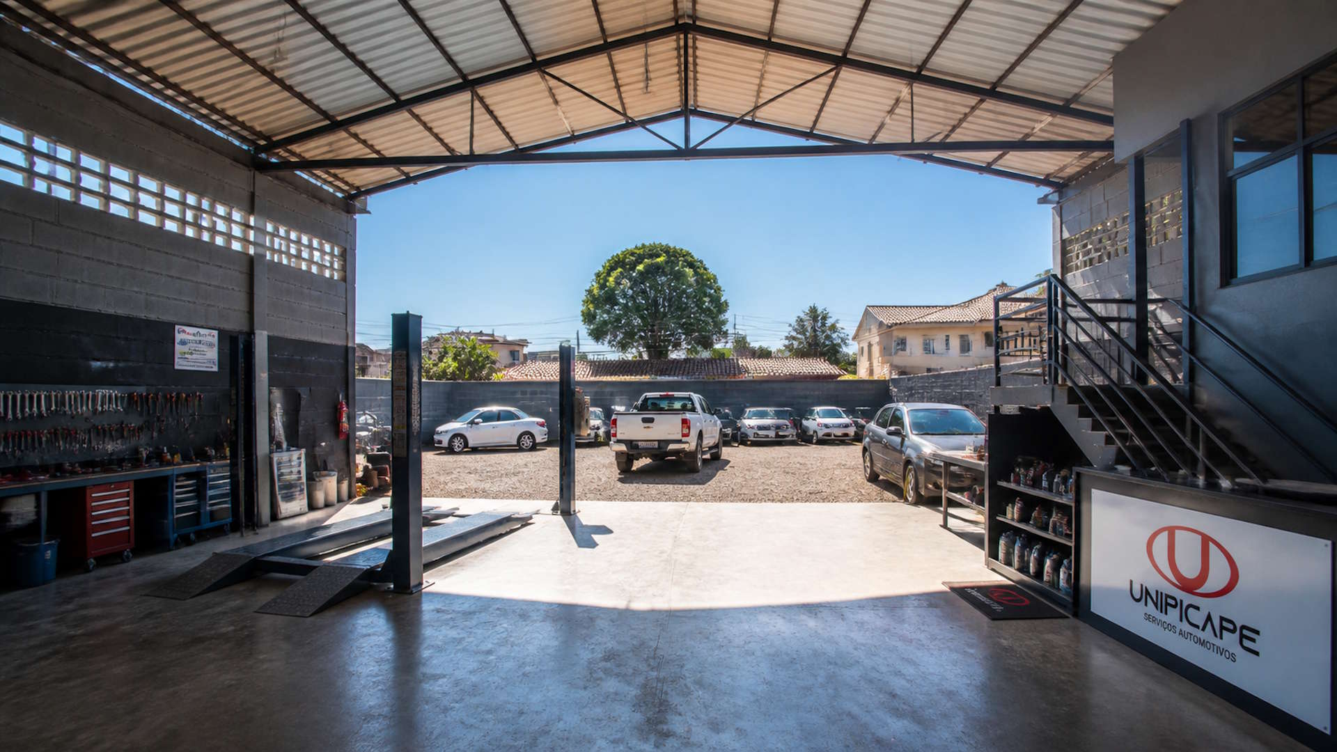 Picapes e SUVs estacionadas em frente à oficina
